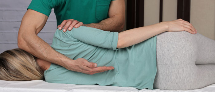 A chiropractor checking a patients spinal alignment